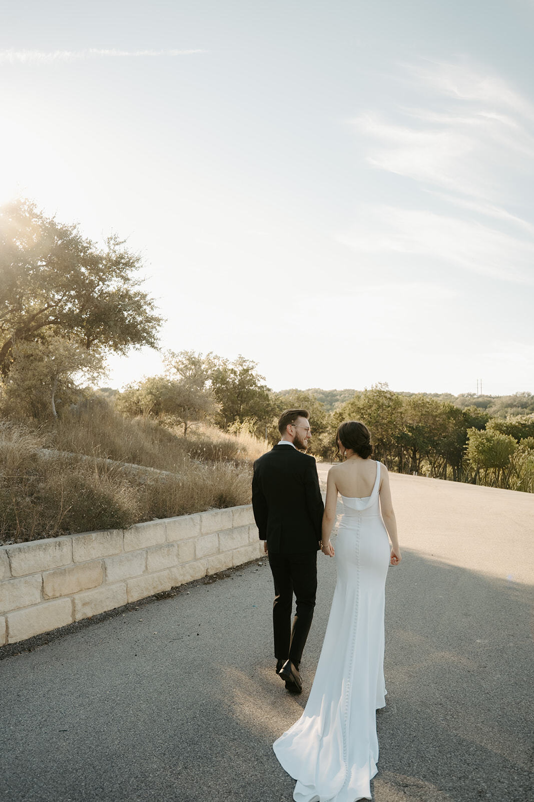 Newlyweds walking through the Hill Country at Las Luces Village