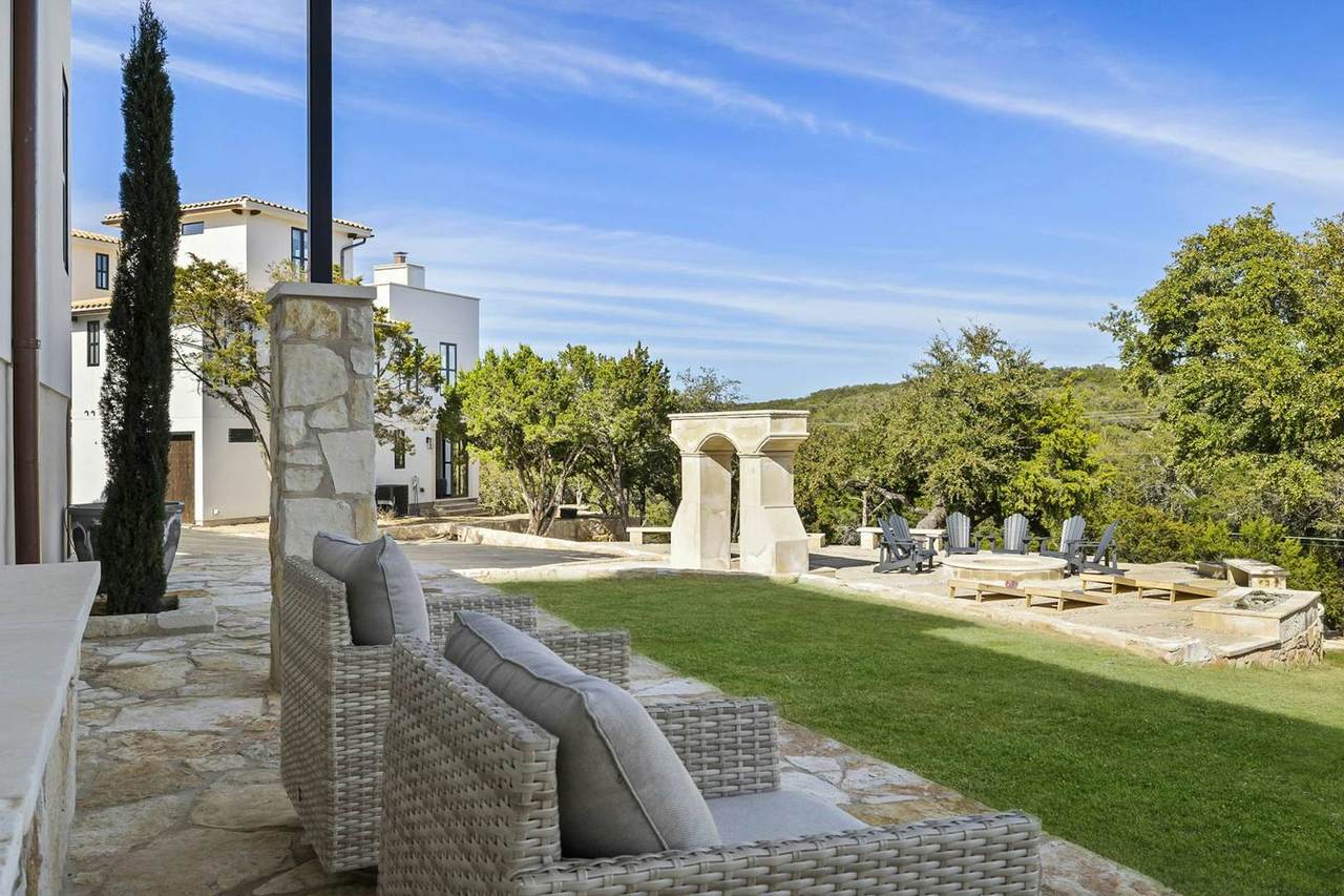 Stone patio with wicker sofas beside a fire pit at Las Luces Village