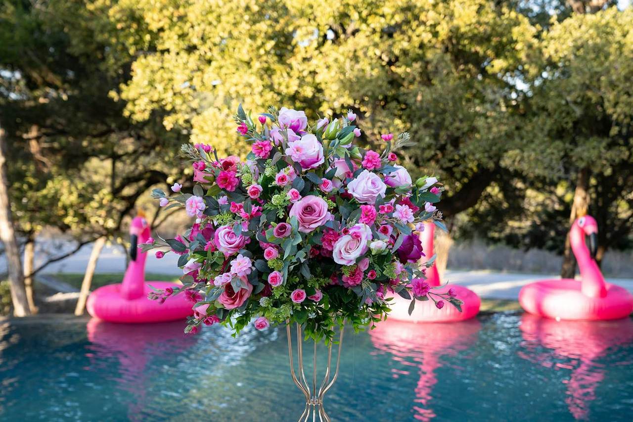 Flowers by the pool with flamingo floats at Las Luces Village